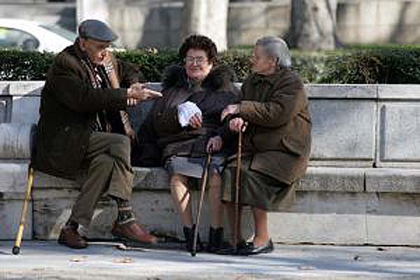 Elderly chatting on a bench in the street